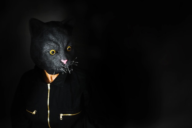 Một người đeo mặt nạ mèo đen anime trong bóng tối. Bức ảnh mang phong cách bí ẩn.