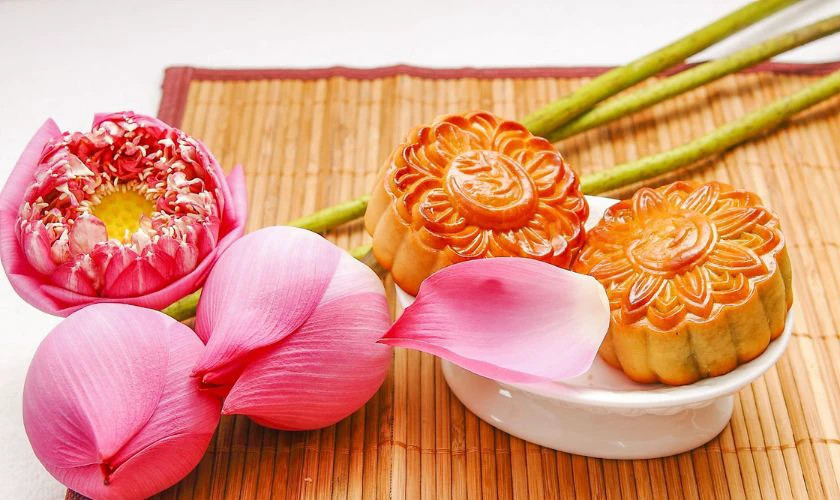 Bánh Trung Thu dẻo và nướng được đặt cạnh hoa sen trang nhã