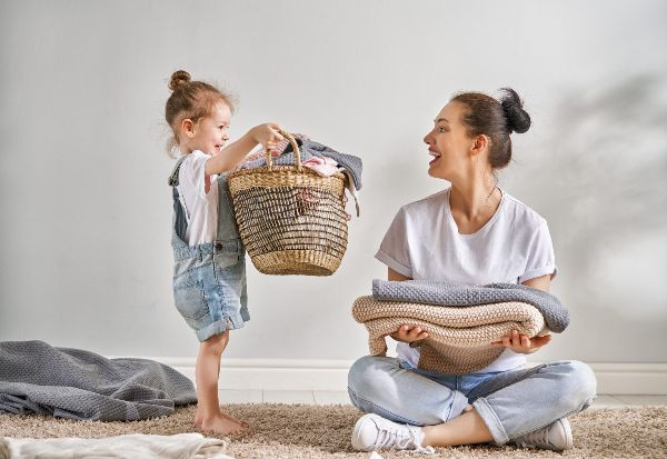 Bé gái tích cực phụ mẹ thu dọn quần áo, học cách giúp đỡ