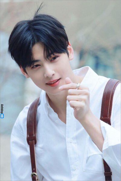 Chàng trai trẻ với mái tóc đầu nấm mỉm cười nhẹ nhàng