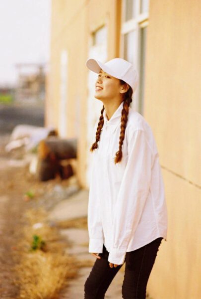 Cô gái xinh xắn đội mũ lưỡi trai màu đen tạo dáng đáng yêu