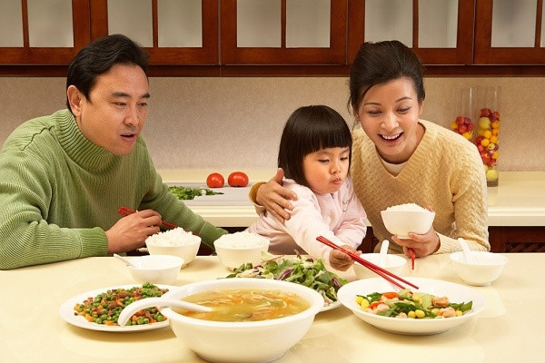 Gia đình ba người tận hưởng bữa ăn ấm áp tại nhà hàng