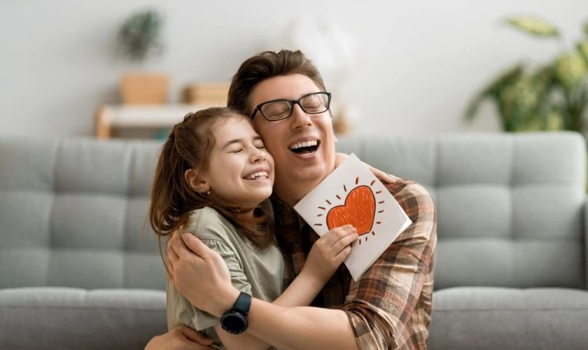 Hình ảnh cha và con cùng cười đùa, biểu cảm ngộ nghĩnh.