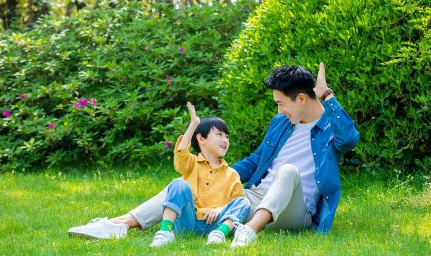 Hình ảnh cha và con trai cùng chơi bóng, thể hiện sự năng động.