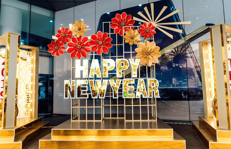 Mẫu vẽ đầu báo tường chủ đề ngày Tết cổ truyền với hoa đào, bánh chưng và câu đối đỏ, thể hiện không khí xuân rộn ràng