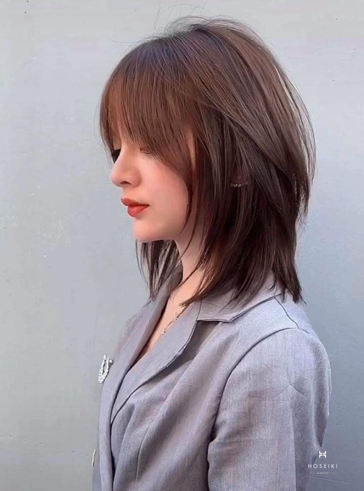 Một cô gái với mái tóc layer ngang vai nhuộm màu sáng, thể hiện phong cách cá tính và thời thượng.