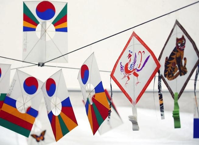 Phác thảo cơ bản hình dáng cánh diều và người thả diều trên giấy trắng