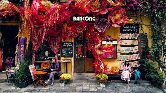 Tranh vẽ gia đình bên mâm cơm ngày Tết với không khí rộn ràng và nhiều món ăn truyền thống