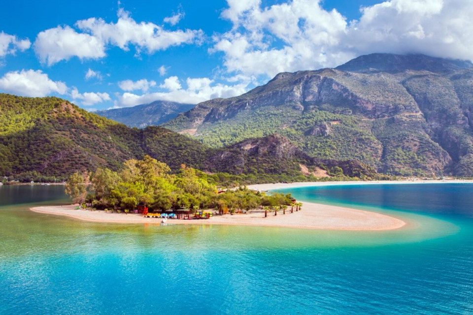 Bức tranh vẽ chủ đề mùa hè với bãi biển cát trắng mịn màng và làn nước trong xanh ngắt