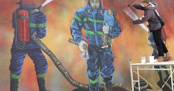 Bức tranh vẽ những người lính cứu hỏa đang dũng cảm chiến đấu với ngọn lửa để cứu người và tài sản